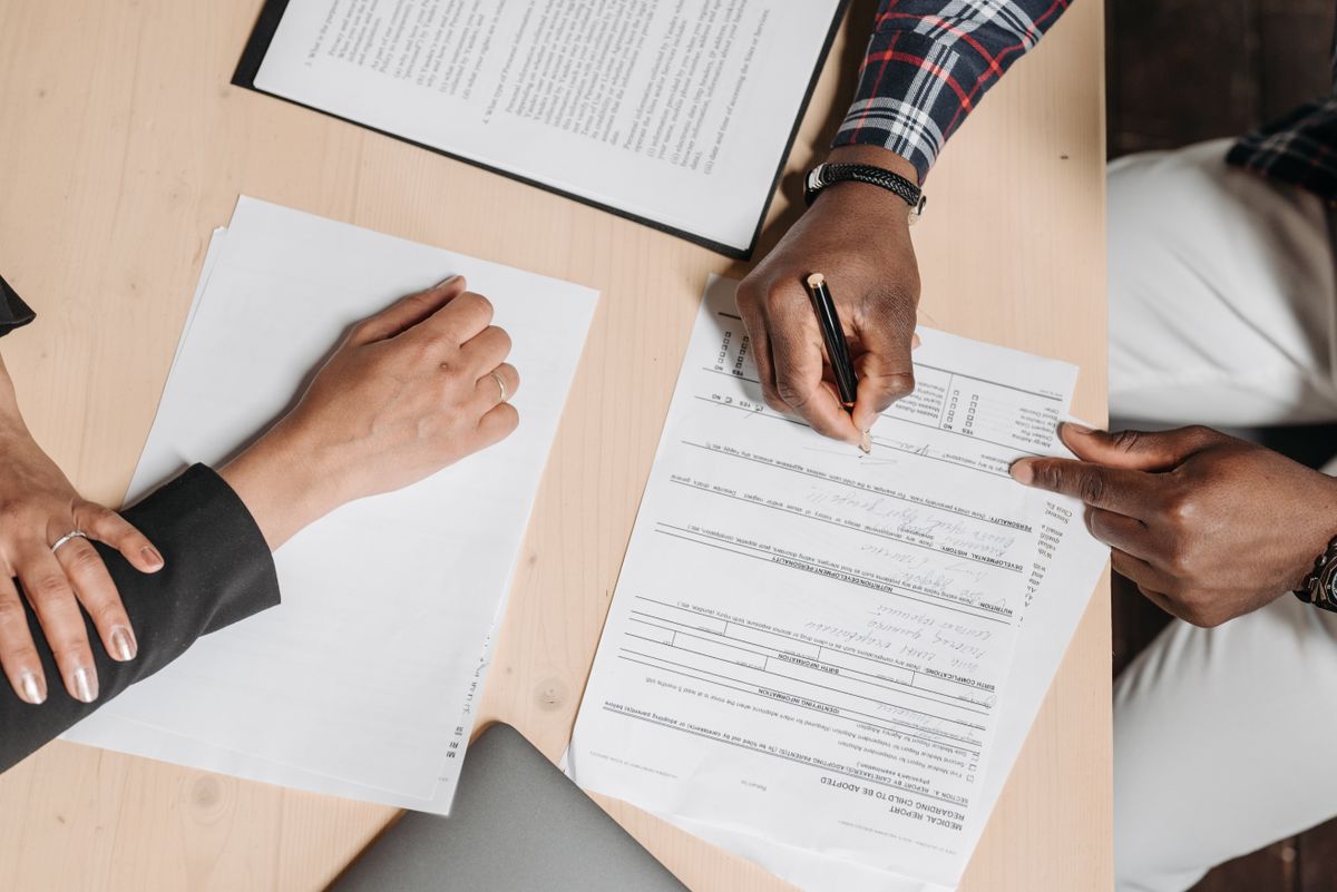 Persoon werkt met papieren documenten en facturen aan een bureau, illustratie bij AI-documentverwerking