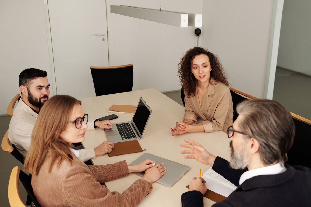 Zakelijk overleg aan tafel waar een AI-notuleerapparaat het gesprek zou kunnen vastleggen