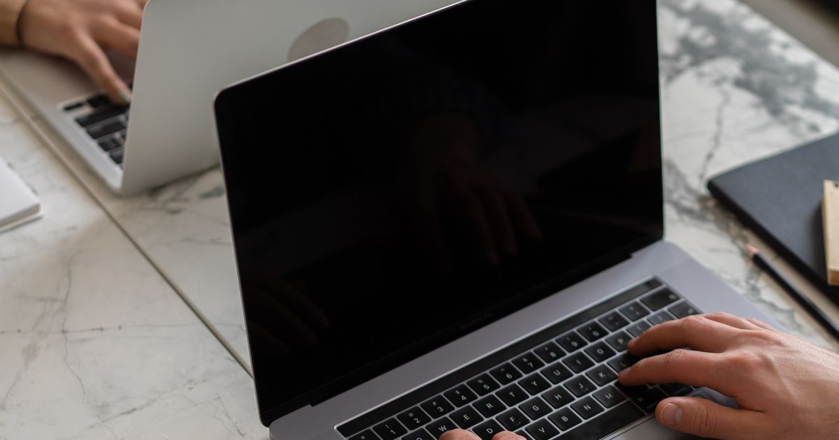 AI voor je nieuwsbrief: twee ondernemers werken samen aan e-mailmarketing op laptops in een modern kantoor