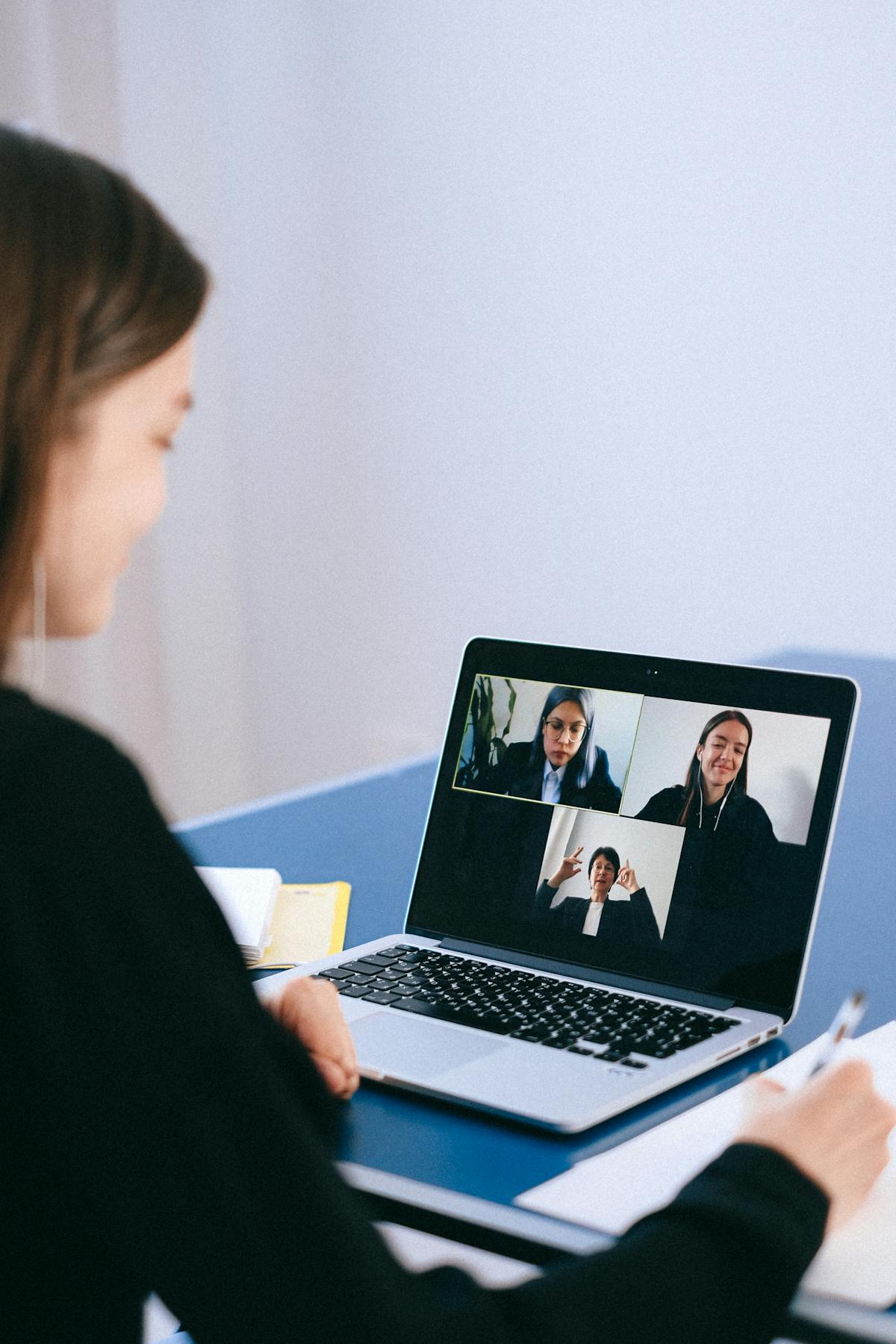 Professional in een Teams-vergadering die automatisch notuleren gebruikt via een videogesprek op een laptop
