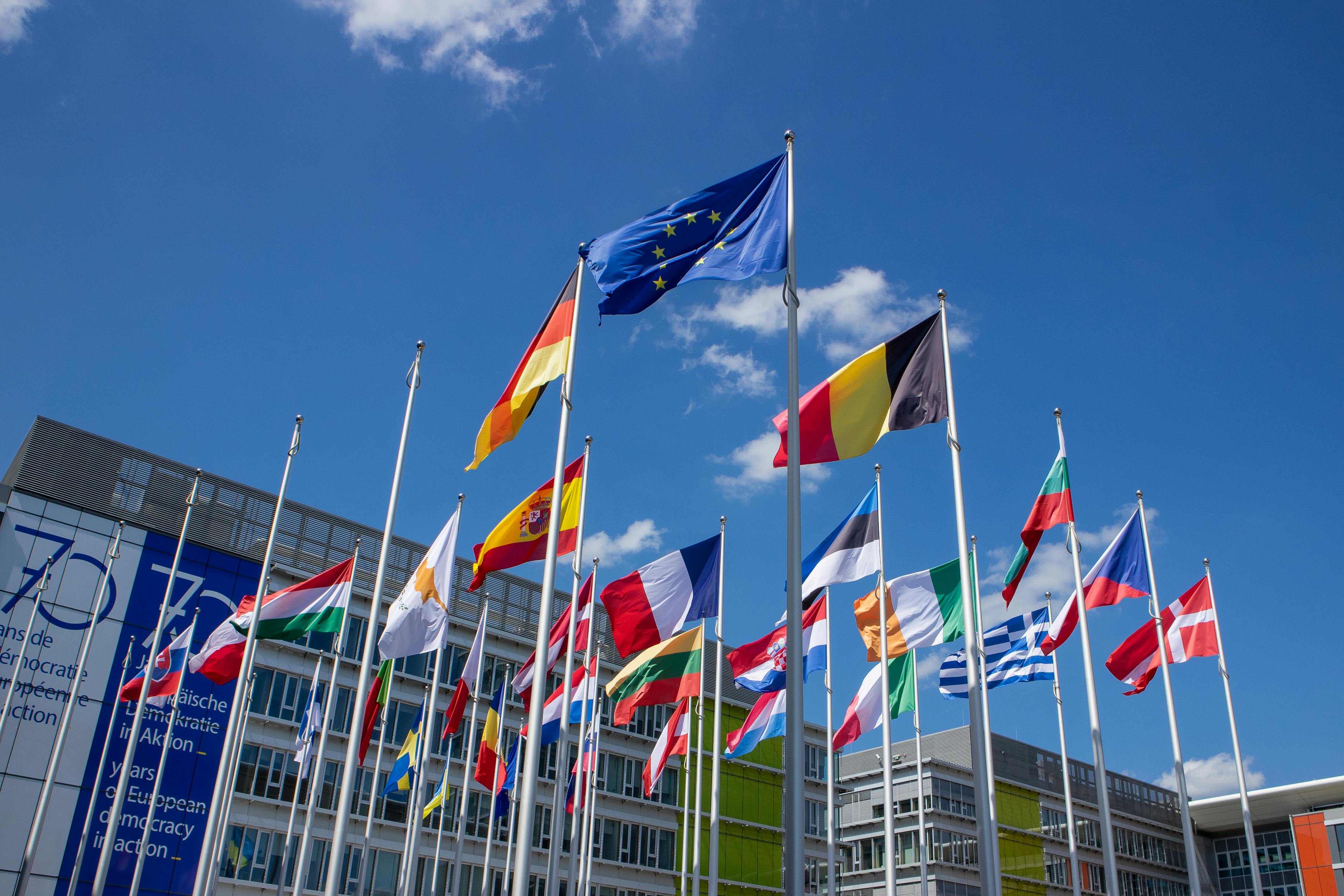 EU AI Act voor MKB: vlaggen van de Europese Unie tegen blauwe lucht als symbool van Europese regelgeving
