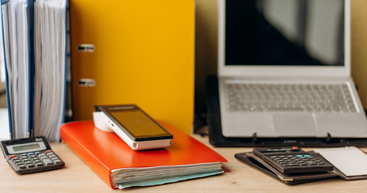 Zzp'er gebruikt AI voor de administratie: bureau met laptop, documenten en rekenmachine voor offertes en btw