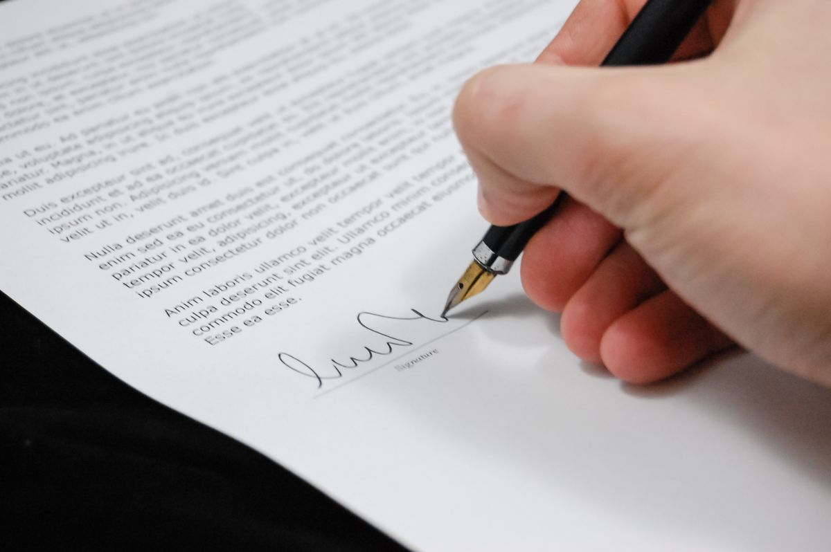 Hand ondertekent een document met een vulpen, bij het onderwerp AI akten opstellen in het notariaat