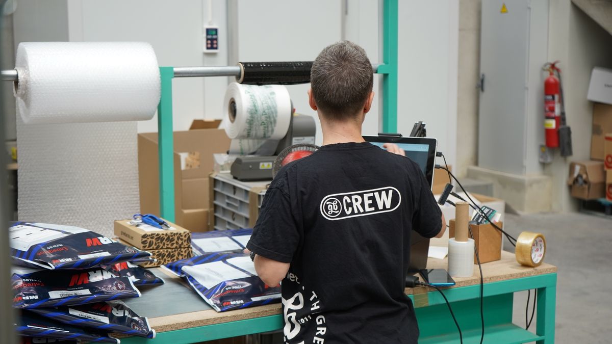 Magazijnmedewerker achter een computer controleert orders, illustratie bij AI orderafhandeling