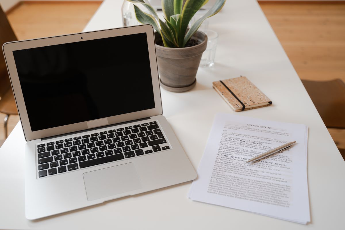 Laptop en dossierstukken op een bureau: AI zoeken in dossiers bij een notariskantoor