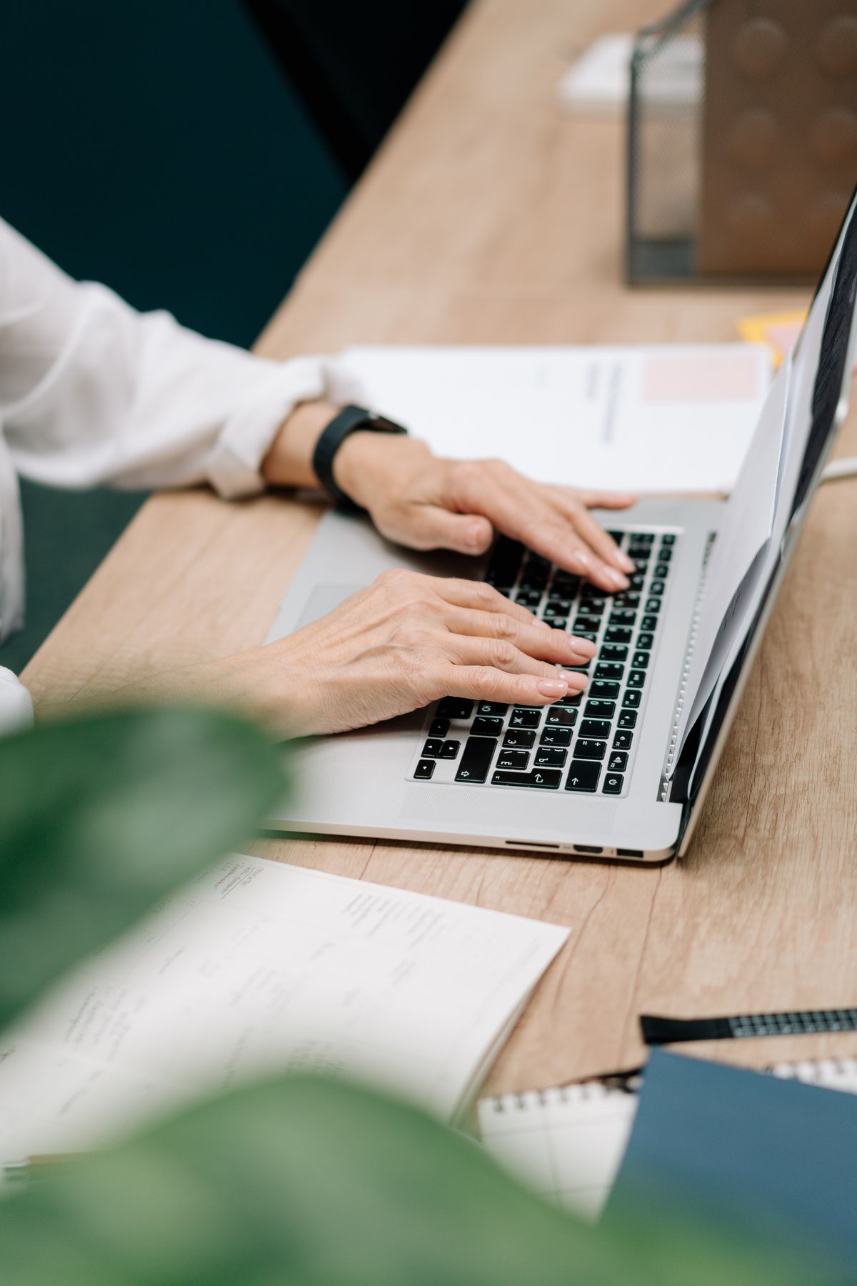 Ondernemer typt op een laptop aan een bureau terwijl zij LinkedIn-posts schrijft met AI