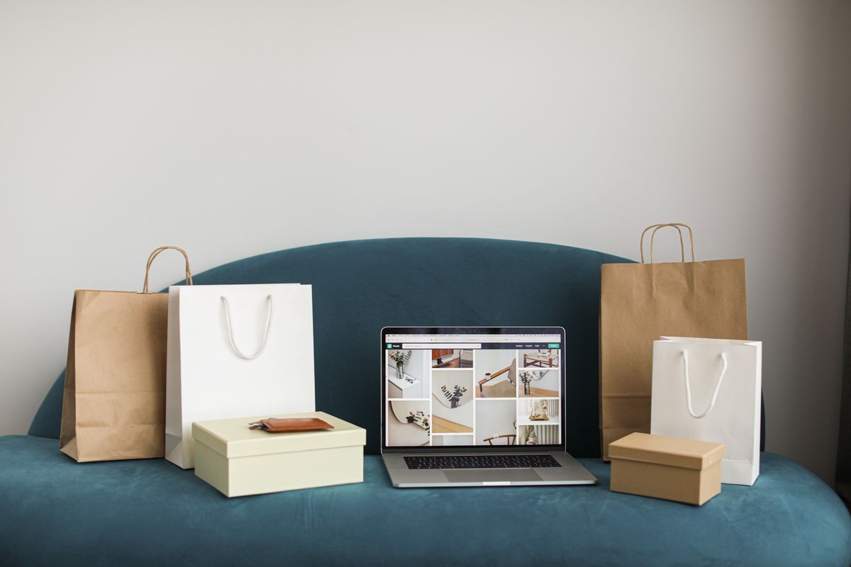 Laptop met webshop naast inpakdozen, symbool voor productbeschrijvingen schrijven met AI